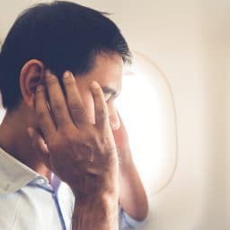 Male passenger having ear pop on the airplane