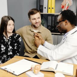 Audiologist discussing rechargeable hearing aids with his patients.